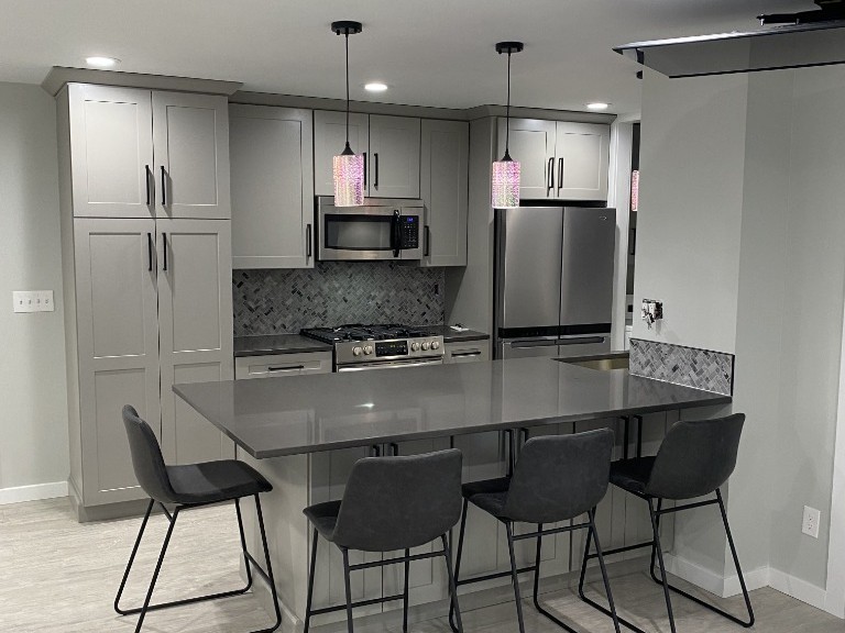 Finished kitchen remodel with quartz island seating, herringbone tile backsplash and pendant lighting in Kitsap County, WA