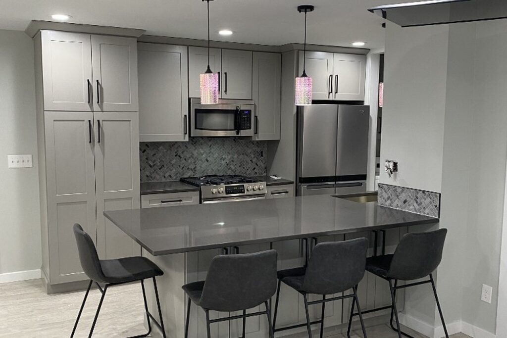 Finished kitchen remodel with quartz island, grey shaker cabinets and herringbone tile backsplash in Kitsap County, WA